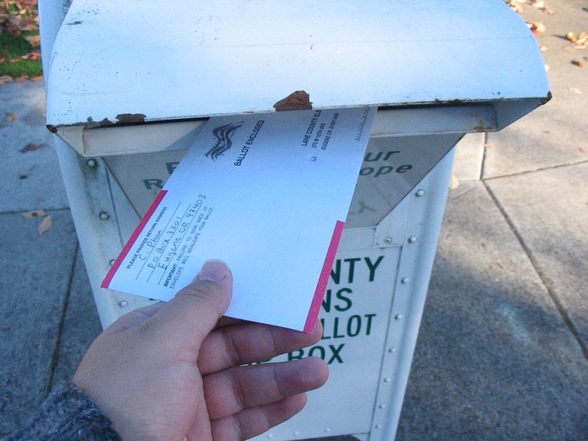A voter returns their ballot in Oregon