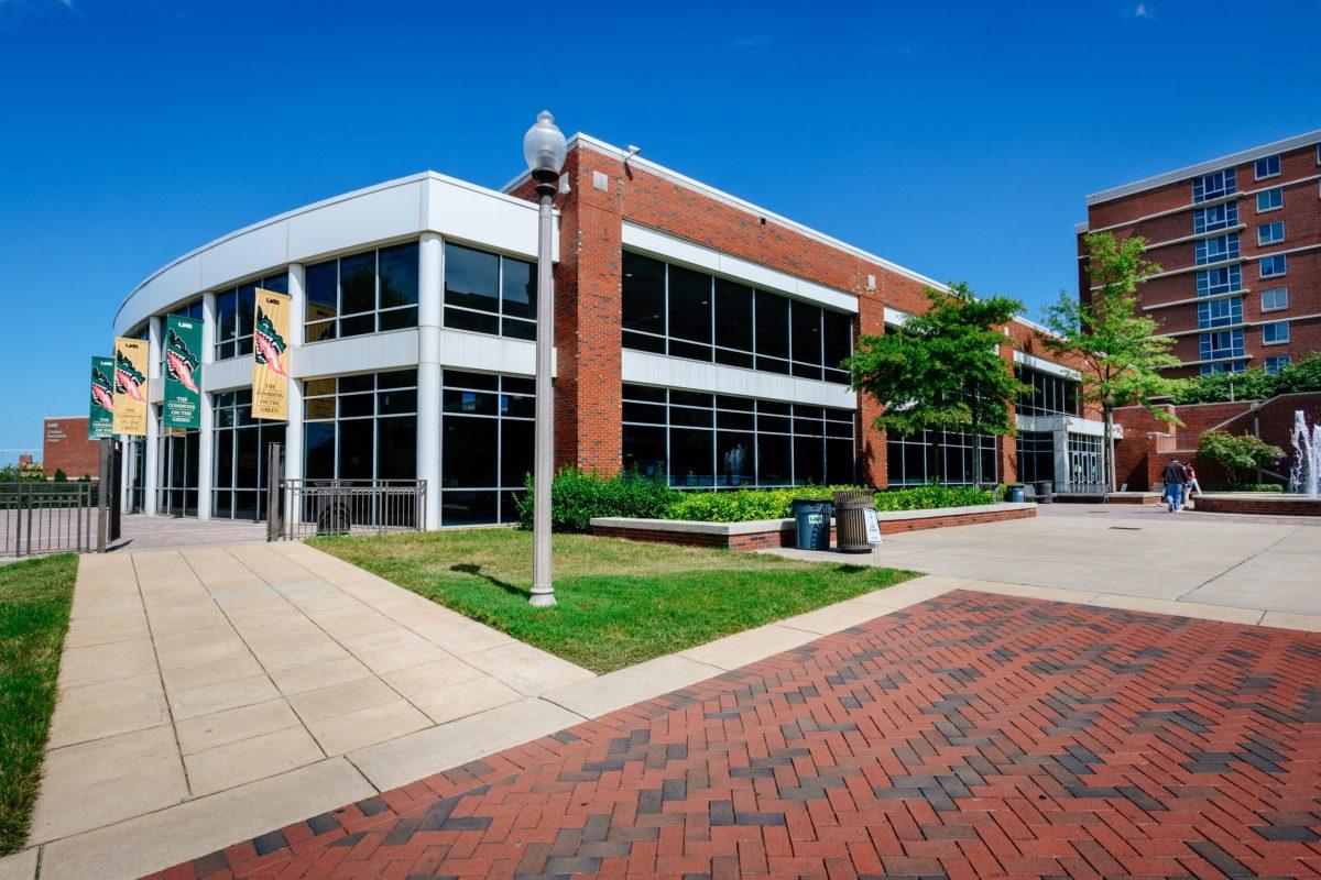 Side angle exterior of Commons on the Green with yellow and green banners hanging out front, September 2020.